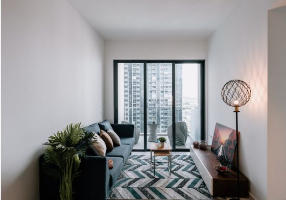 Wide-angle listing photo of a living room with balcony